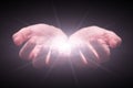 Woman hands cupped protecting and holding bright, glowing, radiant, shining light. Emitting rays or beams expanding Royalty Free Stock Photo