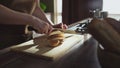 Woman hands cutting bread loaf with knife on home kitchen Royalty Free Stock Photo