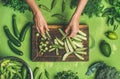 Woman hands cutting green vegetables and greens