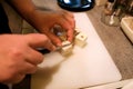 Woman hands cutting piece of cheese, she prepare food at kitchen. Chef cutting cheese with knife on wooden board. Royalty Free Stock Photo