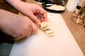 Woman hands cutting piece of cheese, she prepare food at kitchen. Chef cutting cheese with knife on wooden board. Royalty Free Stock Photo