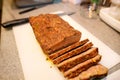 Woman hands cutting piece of meatloaf, she prepare for tasting of food at kitchen. Chef cutting meatloaf with knife on board. Royalty Free Stock Photo