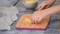 Woman hands cutting pineapple on small pieces.