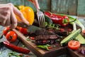 Woman hands cutting well done steak on oak board served with chi Royalty Free Stock Photo