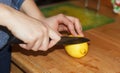 Woman hands cutting a yellow big lemon a kitchen knife Royalty Free Stock Photo