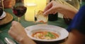 Woman hands detail while eating using fork during a romantic gourmet dinner or lunch.Wide shot. Friends italian trip