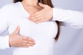 Woman hands doing breast self exam for checking lumps and signs of breast cancer on grey background. Medical, healthcare for Royalty Free Stock Photo