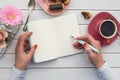Woman hands drawing or writing with ink pen in open notebook on white wooden table. Royalty Free Stock Photo