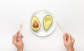 Woman hands eating avocado of bioplastic single use cutlery