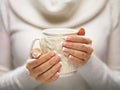 Woman hands with elegant french manicure nails design holding a cozy knitted mug. Winter and Christmas time concept. Royalty Free Stock Photo