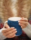 Woman hands with elegant french manicure nails design holding a cozy knitted mug. Winter and Christmas time concept. Royalty Free Stock Photo