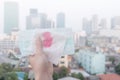 Woman hands or female hands holding a protective mask and napkin with blood because of air pollution in the city have particulate.