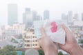 Woman hands or female hands holding a protective mask and napkin with blood because of air pollution in the city have particulate.