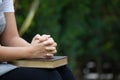 Woman hands folded in prayer on a Holy Bible for faith concept Royalty Free Stock Photo