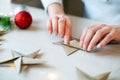 Woman hands folding origami paper star for Christmas decoration Royalty Free Stock Photo