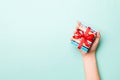 Woman hands give wrapped christmas or other holiday handmade present in colored paper. Present box, decoration of gift on Blue Royalty Free Stock Photo