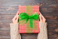 Woman hands give wrapped christmas or other holiday handmade present in colored paper . Present box, decoration of gift on dark Royalty Free Stock Photo
