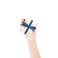Woman hands give wrapped Christmas or other holiday handmade present in gold paper with blue ribbon. Isolated on white background Royalty Free Stock Photo