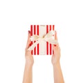 Woman hands give wrapped Christmas or other holiday handmade present in red paper with gold ribbon. Isolated on white background, Royalty Free Stock Photo