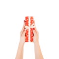 Woman hands give wrapped Christmas or other holiday handmade present in red paper with Gold ribbon. Isolated on white background, Royalty Free Stock Photo