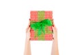 Woman hands give wrapped Christmas or other holiday handmade present in red paper with Green ribbon. Isolated on white background Royalty Free Stock Photo