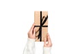 Woman hands give wrapped valentine or other holiday handmade present in paper with black ribbon. Present box, decoration of gift Royalty Free Stock Photo