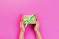 Woman hands give wrapped valentine or other holiday handmade present in paper with green ribbon. Present box, decoration of gift Royalty Free Stock Photo