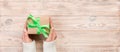 Woman hands give wrapped valentine or other holiday handmade present in paper with green ribbon. Present box, decoration of gift Royalty Free Stock Photo