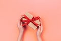 Woman hands give wrapped valentine or other holiday handmade present in paper with red ribbon. Present box, decoration of gift on Royalty Free Stock Photo