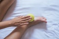 Woman hand giving massage with tennis ball to her foots in bedroom,foot soles massage Royalty Free Stock Photo