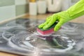 Woman hands in gloves cleans kitchen electric ceramic hob Royalty Free Stock Photo