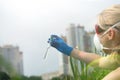 Woman with hands in gloves holds a glass with a sample of water. Sampling from open water Royalty Free Stock Photo