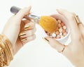 Woman hands with golden manicure and many rings holding brushes, makeup artist stuff stylish, pure close up pink Royalty Free Stock Photo