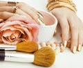 Woman hands with golden manicure and many rings holding brushes, makeup artist stuff stylish, pure close up pink Royalty Free Stock Photo