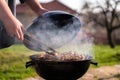 Woman hands grilling barbecue meet on the grill outdoors in the back yard. Summer time picnic. Roasting meat on metal grid on hot Royalty Free Stock Photo