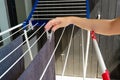 Woman hands hanging her laundry on balcony on the drying rack. Female Hanging Clothes On Clothes Line Outdoors Royalty Free Stock Photo