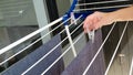 Woman hands hanging her laundry on balcony on the drying rack. Female Hanging Clothes On Clothes Line Outdoors Royalty Free Stock Photo