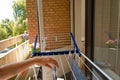 Woman hands hanging her laundry on balcony on the drying rack. Female Hanging Clothes On Clothes Line Outdoors Royalty Free Stock Photo