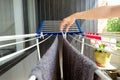 Woman hands hanging her laundry on balcony on the drying rack. Female Hanging Clothes On Clothes Line Outdoors Royalty Free Stock Photo