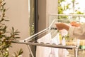 Woman hands hanging her laundry on balcony on the drying rack opposite sea and palm trees view at sunset sunshine. Royalty Free Stock Photo