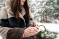 Woman hands hold a cup of tea with lemon on a cold winter day in a snow forest Royalty Free Stock Photo
