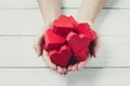 Woman Hands Hold Red Paper Hearts on white wood background. Giving Love Concept Royalty Free Stock Photo