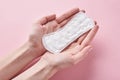 Woman hands hold sanitary pad on a pink background Royalty Free Stock Photo