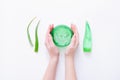 Woman hands holding aloe gel. Aloe vera leaves and cosmetic products on white surface. Top view Royalty Free Stock Photo