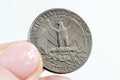 Woman hands holding American Quarter Dollar coin on light background close up. Royalty Free Stock Photo