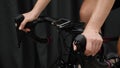 Woman hands holding bicycle handlebar with computer showing speed power heartrate data. Cycling training indoors on smart trainer.