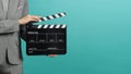 Woman hands holding black Clapperboard or film slate and wear grey suit. it use in videography ,movies and cinema industry on