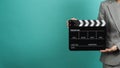 Woman hands holding black Clapperboard or film slate and wear grey suit. it use in videography ,movies and cinema industry on