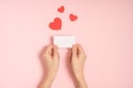 Woman hands holding blank Valentine card on pink table Royalty Free Stock Photo