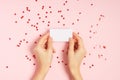 Woman hands holding blank Valentine card on pink table Royalty Free Stock Photo